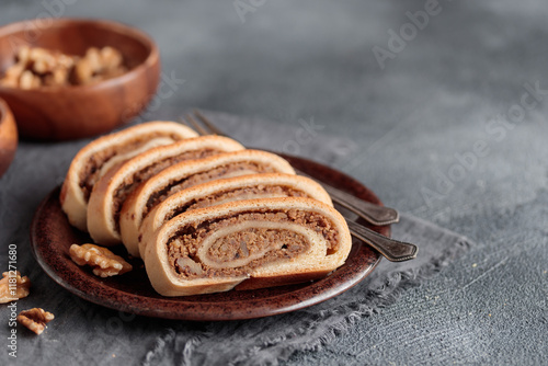 Bejgli, home-baked walnut roll, traditional Hungarian, Eastern European Christmas and Easter sweet bread in slices stuffed with ground walnuts filling. Copy space photo