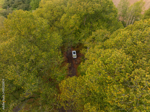 Aerial view of autumn forest with camper van among lush trees, Kocov, Czech Republic. photo