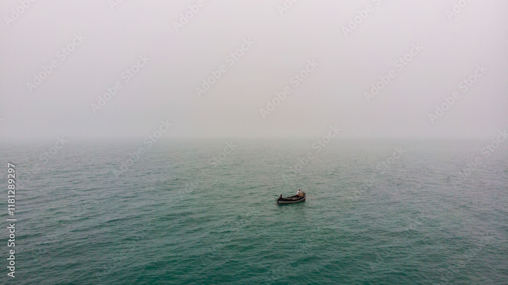 Aerial view of a serene fishing boat in fog over calm ocean, Varna, Bulgaria. Aerial view of a serene fishing boat in fog over calm ocean, Varna, Bulgaria.