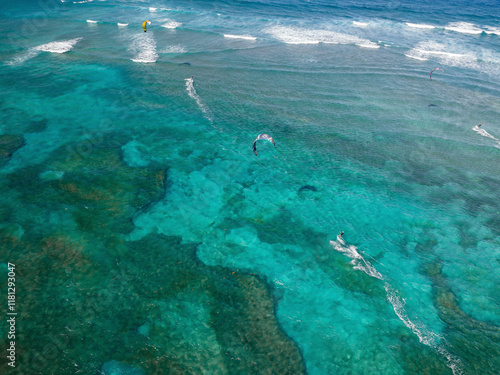 Aerial view of kite surfers riding waves over a beautiful turquoise ocean with coral reefs, Sosua, Dominican Republic. photo