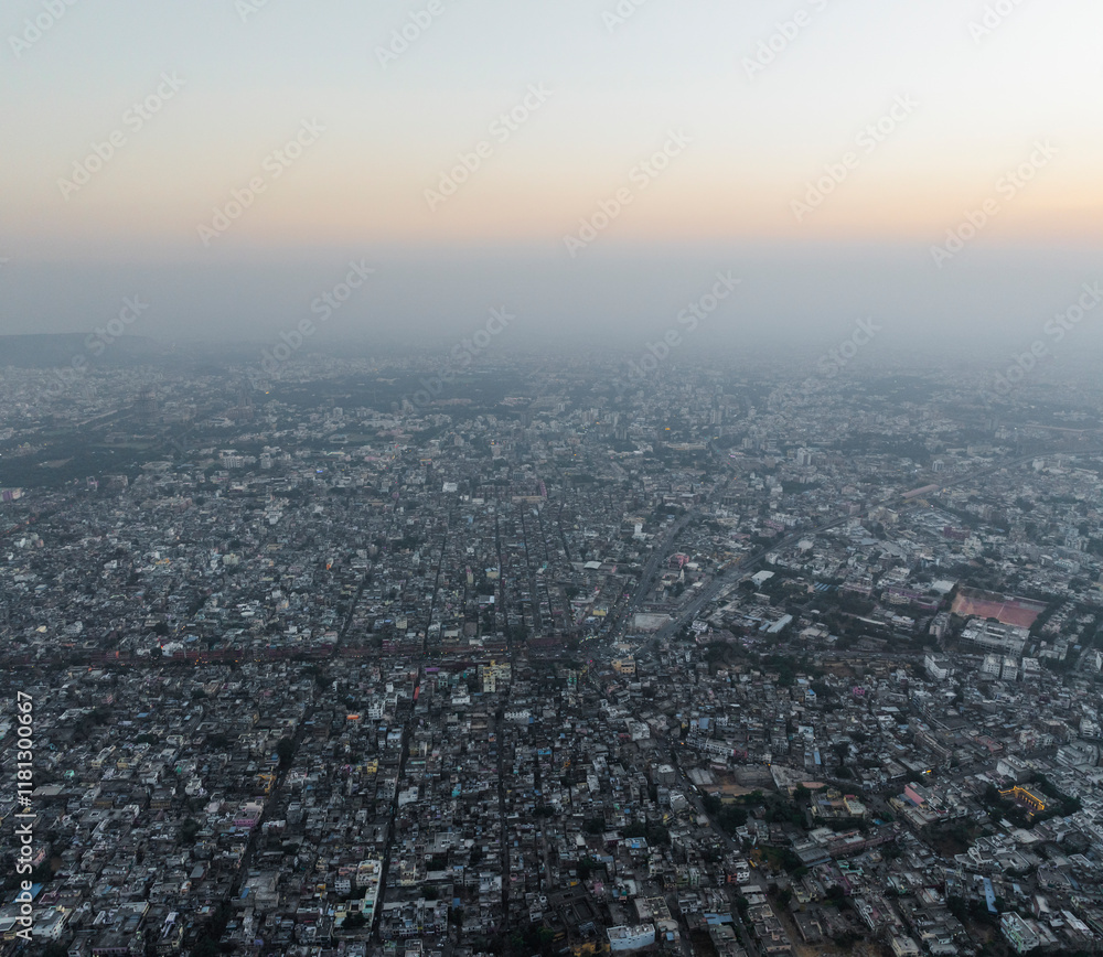 Aerial view of expansive cityscape at sunset with dense buildings and skyline, Nahari Ka Naka, Jaipur, Rajasthan, India. Aerial view of expansive cityscape at sunset with dense buildings and skyline, Nahari Ka Naka, Jaipur, Rajasthan, India.