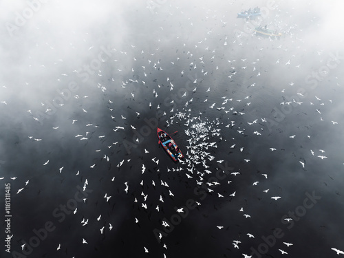 Aerial view of Yamuna Ghat with boats and birds under low clouds and mist, Sadar Bazar, New Delhi, India. photo