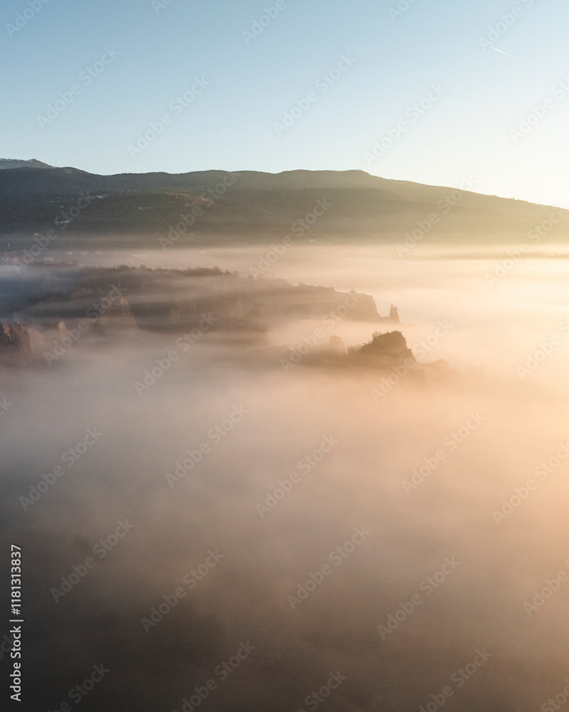 Aerial view of serene fog and mist over majestic mountains at sunrise, Tuscany, Reggello, Italy. Aerial view of serene fog and mist over majestic mountains at sunrise, Tuscany, Reggello, Italy.