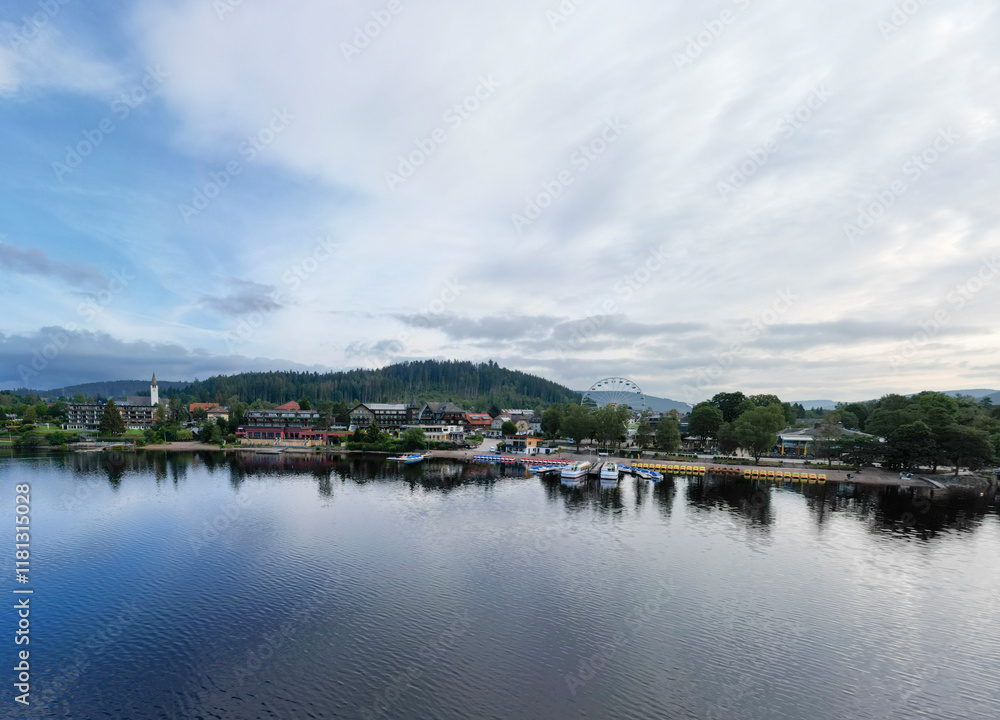 Aerial view of tranquil Lake Titisee surrounded by picturesque village and serene forest in Southern Black Forest Nature Park, Germany. Aerial view of tranquil Lake Titisee surrounded by picturesque village and serene forest in Southern Black Forest Nature Park, Germany.
