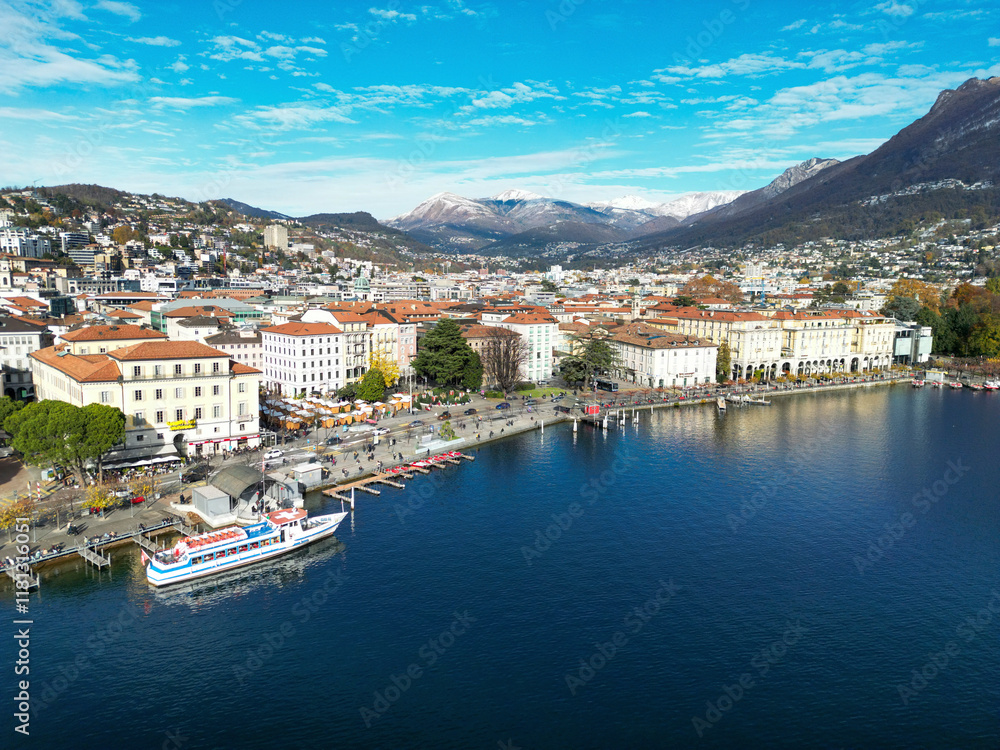 Aerial view of beautiful harbor promenade with vibrant city and serene lake surrounded by mountains, Lugano, Switzerland. Aerial view of beautiful harbor promenade with vibrant city and serene lake surrounded by mountains, Lugano, Switzerland.