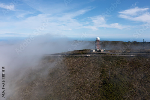 Aerial view of a serene landscape with radar antenna shrouded in fog and clouds, Santa Barbara, Azores, Portugal. photo