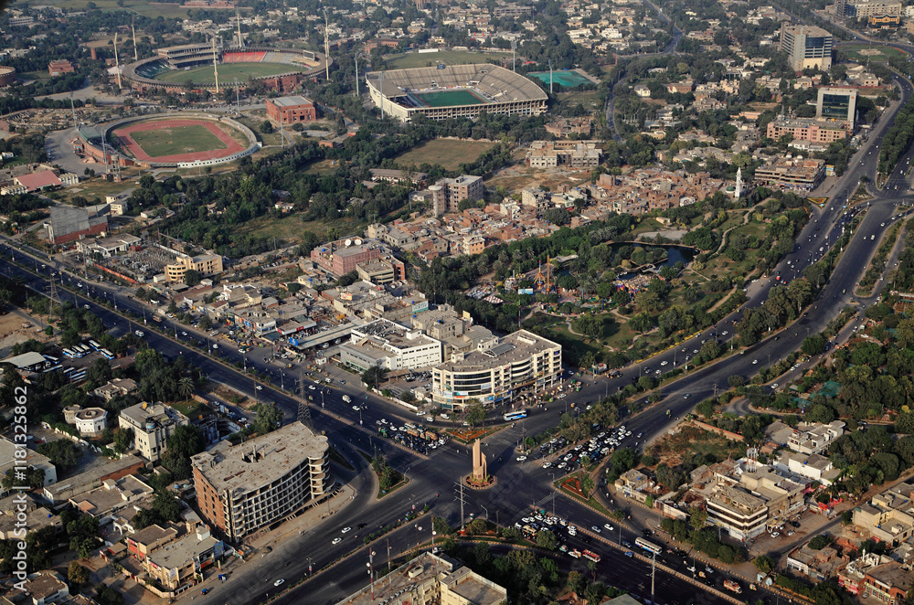 Aerial view of bustling urban landscape with modern architecture and dense traffic at an intersection, Lahore, Pakistan. Aerial view of bustling urban landscape with modern architecture and dense traffic at an intersection, Lahore, Pakistan.