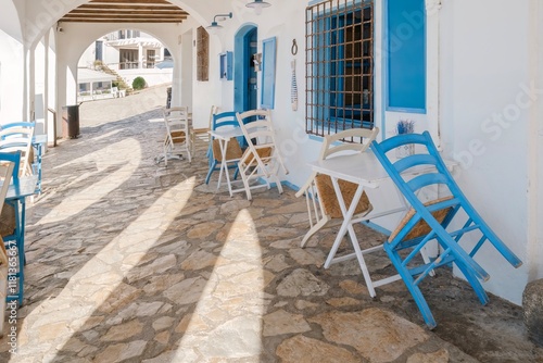 Obraz na płótnie Chairs And Tables In Blue In The Corridor Of The Promenade Of The Picturesque Historical And Tourist City Of Calella De Palafrugell, Costa Brava, Catalonia. w salonie