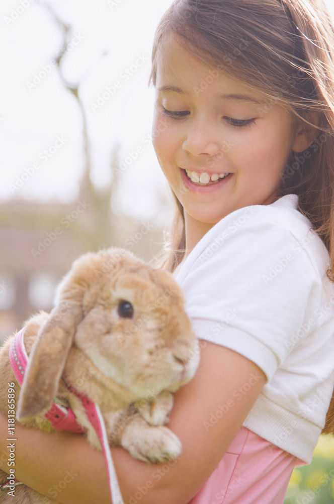 Young girl holding a lop-eared rabbit
Young girl holding a lop-eared rabbit