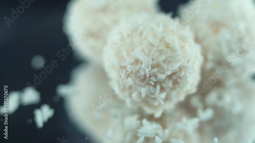 Macro lock on object shot of tasty Raffaello bonbons on a rotating stand, coconut dessert, white coco balls, smooth movement 120 fps slow motion video photo