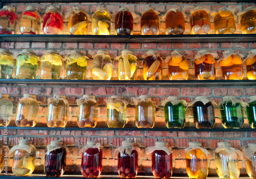 Canned vegetables and fruits in large glass jars on display. Homemade pickles and marinades.