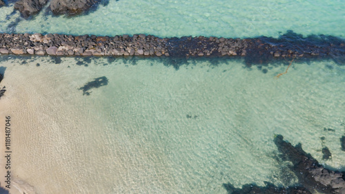 A drone shot of the beautiful emerald sea and clear green waves at Pyoseon Beach in Jeju Island, Korea photo