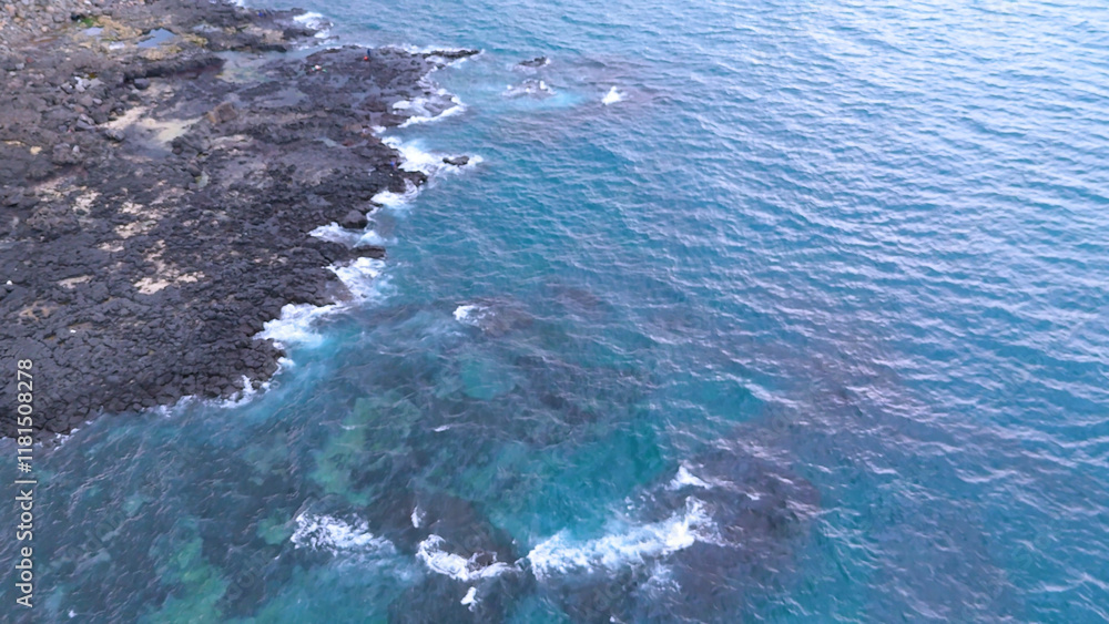 A drone shot of the beautiful sea scenery of Jeju Island, Korea, which boasts a green emerald cleanliness. Best healing trip. Harmony of basalt and waves A drone shot of the beautiful sea scenery of Jeju Island, Korea, which boasts a green emerald cleanliness. Best healing trip. Harmony of basalt and waves