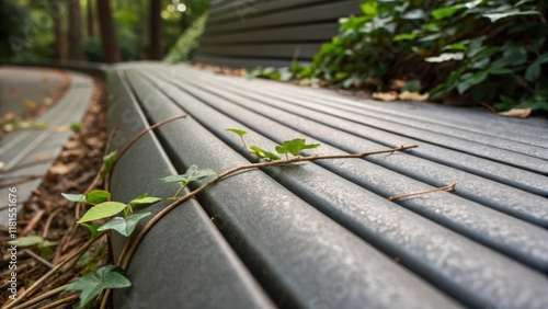 A macro shot of the textured surface on a bench seat featuring subtle grooves designed for grip with small leaves and twigs resting on top hinting at the natural integration of the photo