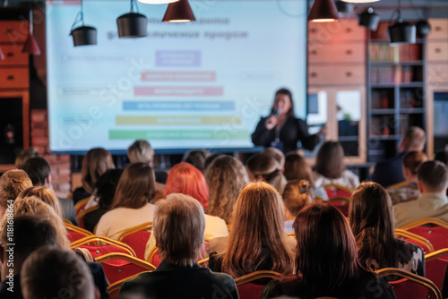 Wallpaper Mural Conference attendees listen to a speaker in a modern venue with presentation slides visible. Torontodigital.ca