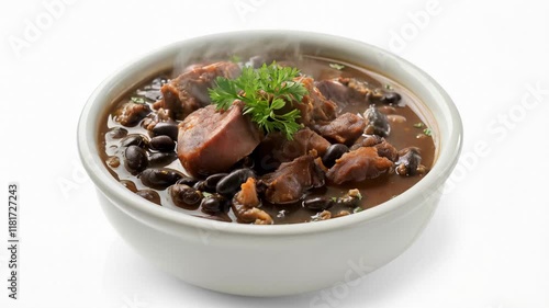 A hearty black bean stew with sausage and fresh parsley garnish served in a white ceramic bowl
