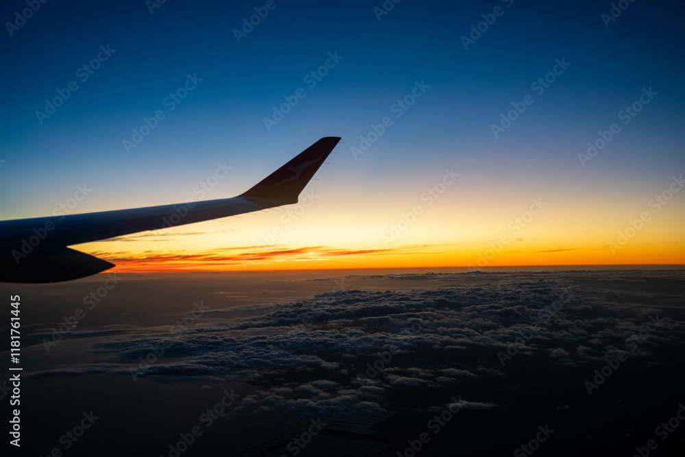 Fototapeta premium on a plane looking over the wing at sunset