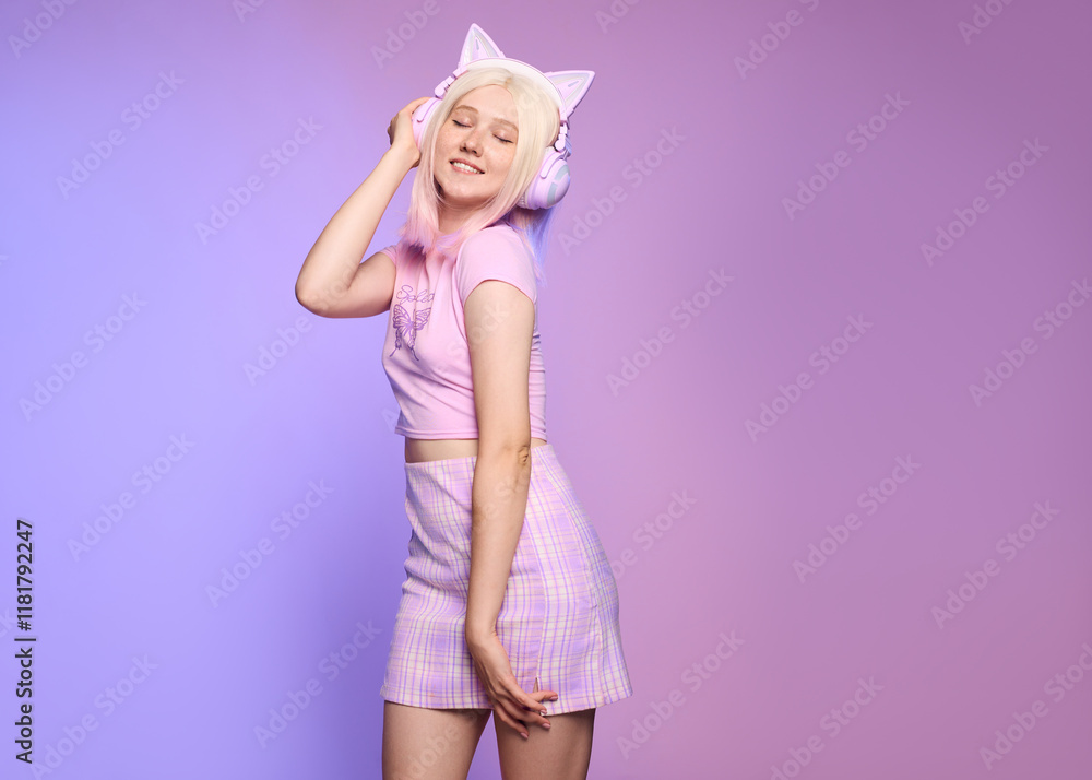 A cute blonde in stylish 2000s 2yk clothes poses happily listening to music on a colored background A cute blonde in stylish 2000s 2yk clothes poses happily listening to music on a colored background