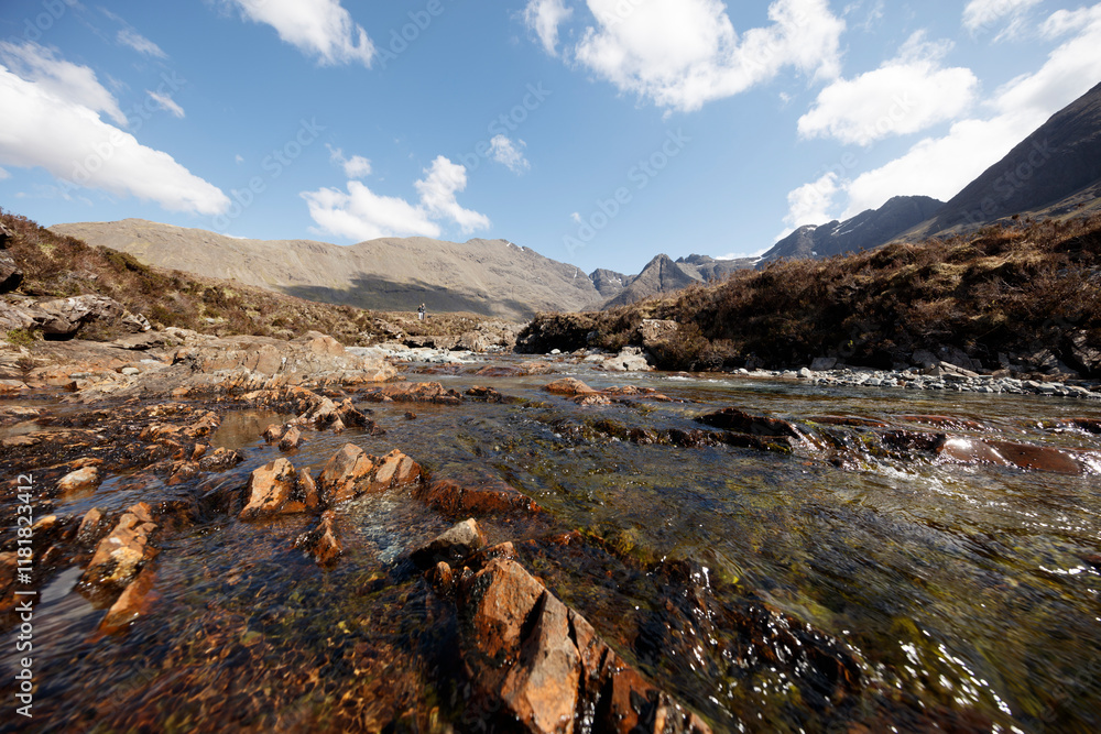 Naklejka premium Scenic river wending through rugged landscapes of Isle of Skye, Scotland on a bright day