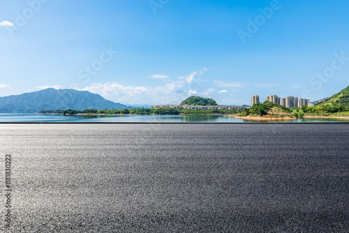 Fototapeta Naklejka Na Ścianę i Meble -  Asphalt road and blue lake with islands nature landscape under blue sky. Outdoor road background.