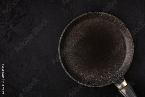 Картината върху платно empty frying pan on black textured slate background with free space for food