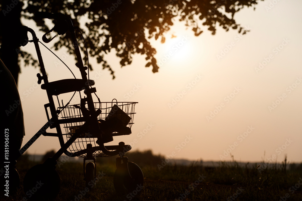 Fototapeta premium Silhouette of a stroller against a sunset in a serene outdoor setting