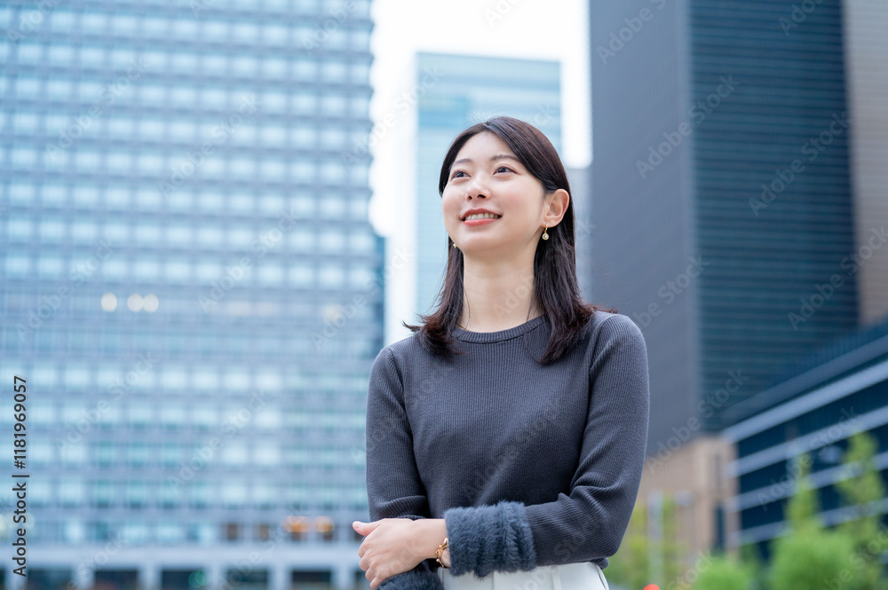 Fototapeta premium ビルを背景に笑顔の日本人女性