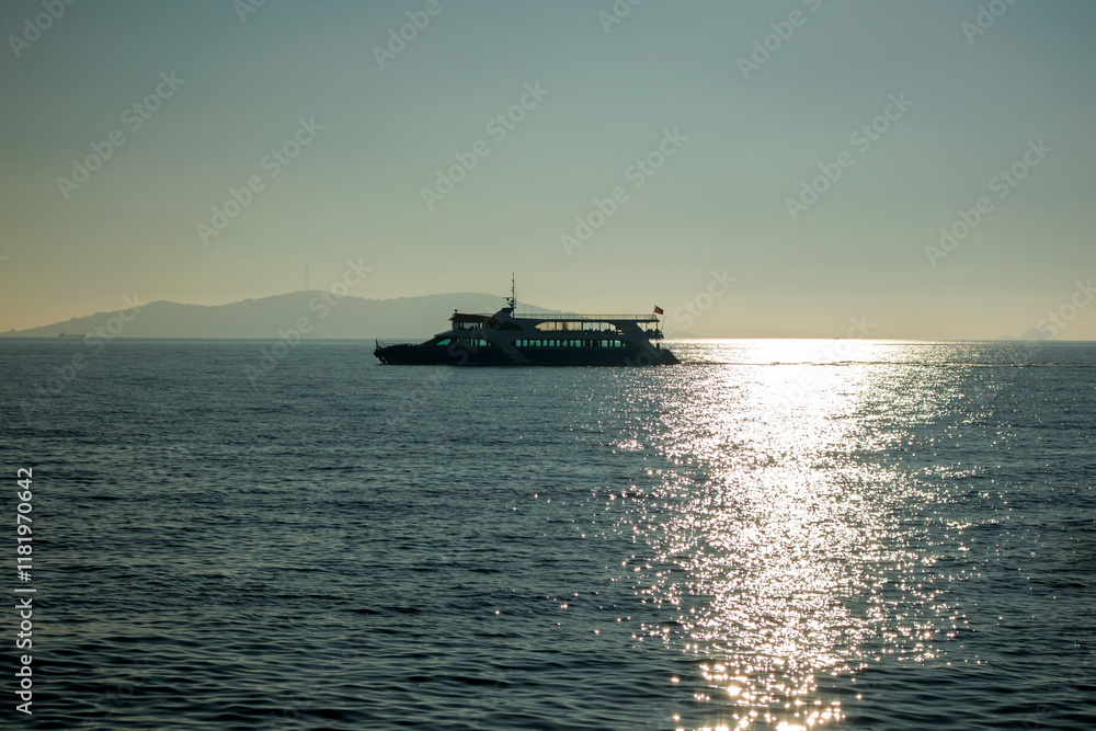 Fototapeta premium Boat sailing on the sea as the sun sets