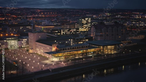 Wallpaper Mural Saxon State Parliament in Dresden captured at night, illuminated against the city skyline. In the foreground, the modern architecture shines, while city lights create a vibrant backdrop. Torontodigital.ca