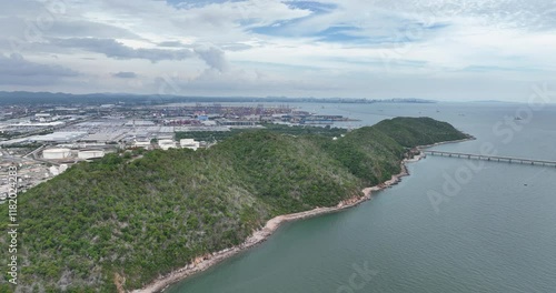 Wallpaper Mural Drone flying over the ocean and green cliffs, revealing a petrochemical refinery under cloudy sky Torontodigital.ca