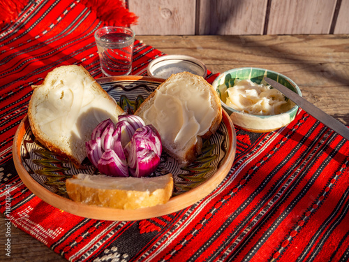 pork lard spread on bread served with red onion and salt and glass of plum brandy aside photo