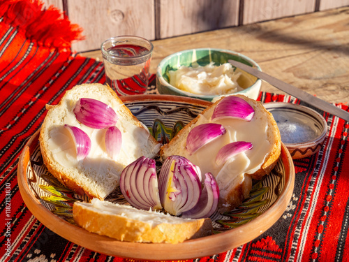 pork lard spread on bread served with red onion and salt and glass of plum brandy aside photo