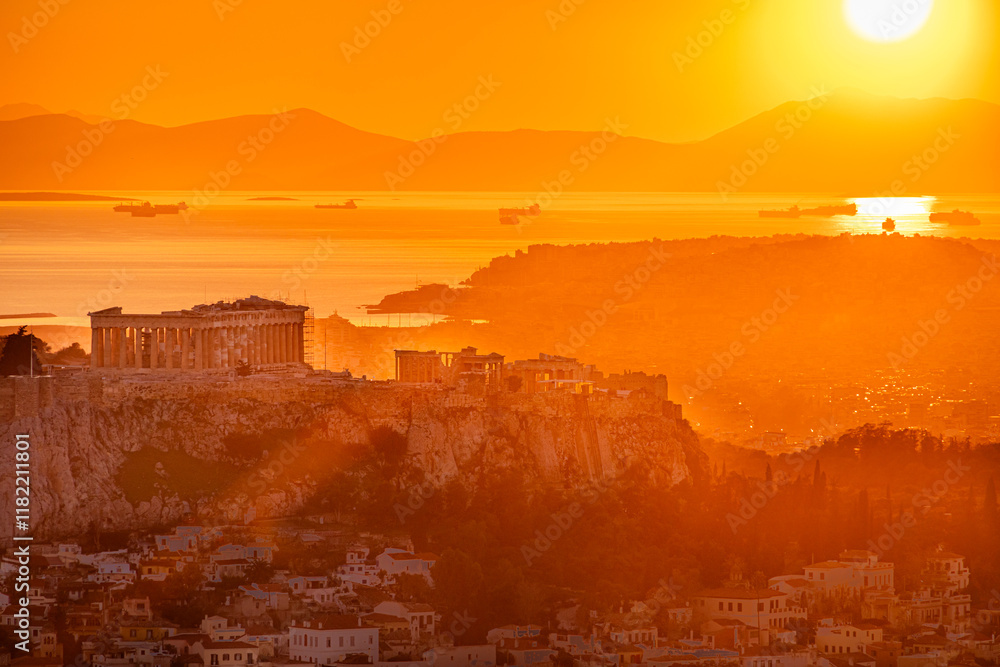Sunset over Arcopolis hill in Athens. Beautiful orange sky landscape, view from above from Lycabetus Hill, to the Anciend World of Parthenon. Travel to Athens, Greece.