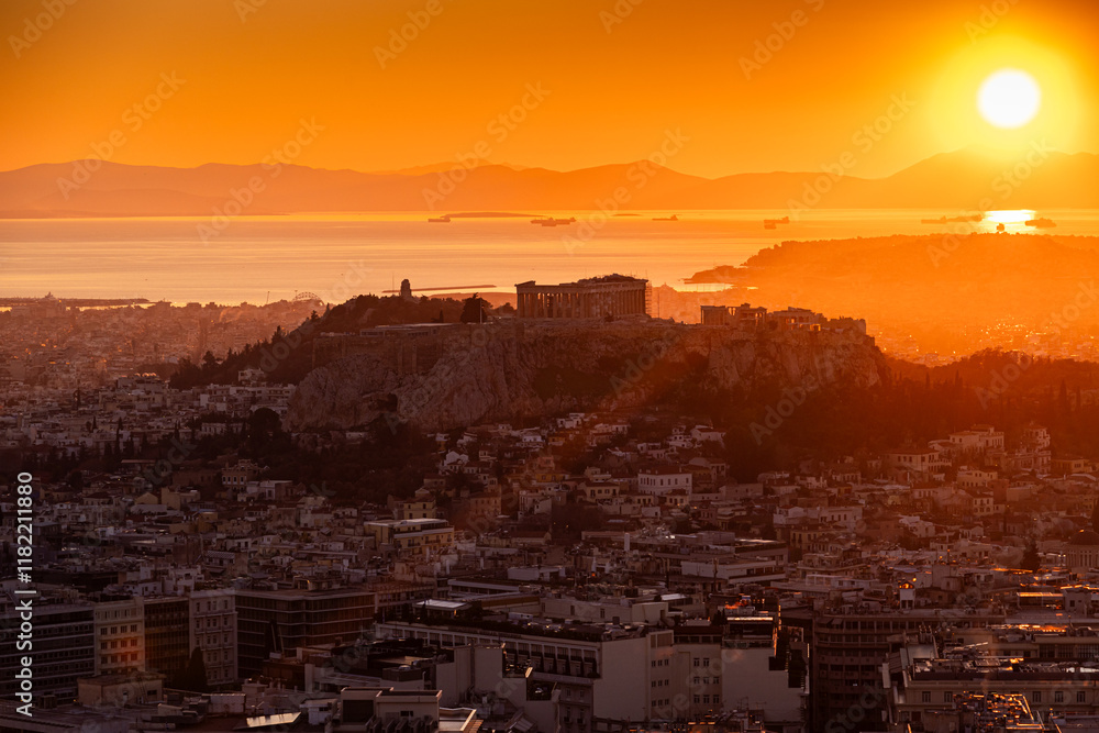 Sunset over Arcopolis hill in Athens. Beautiful orange sky landscape, view from above from Lycabetus Hill, to the Anciend World of Parthenon. Travel to Athens, Greece.