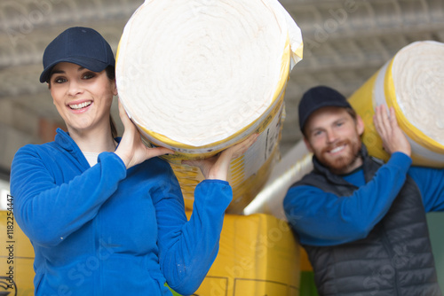 Φωτογραφία caucasian construction workers with roll of insulating material