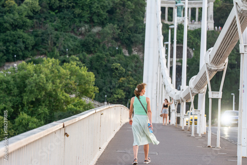 A focused young woman walk across a bridge in a park photo