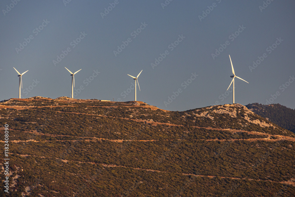 Wind turbines on the hills of Greece. Industrial concept photo for wind mills that produce electricity from wind power. Wind turbines on Parnassus mountain hills in Greece. Green energy.