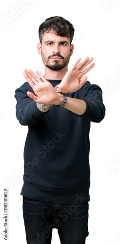 Young handsome man over isolated background Rejection expression crossing arms and palms doing negative sign, angry face photo