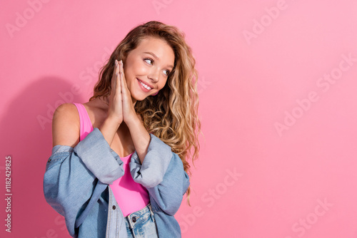 Charming young blonde model in casual denim and pink outfit showing joyful expression against a vibrant pink background photo