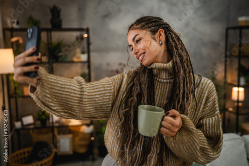 beautiful smiling young woman take a self portrait with mug at home photo