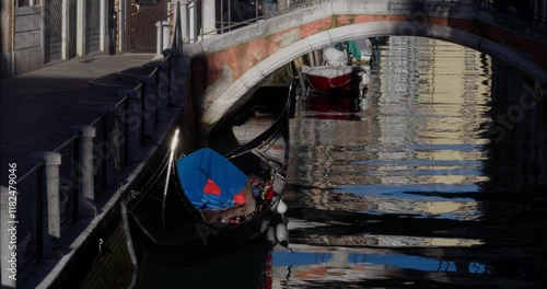 Empty gondola floating by the canals of Venice in the morning