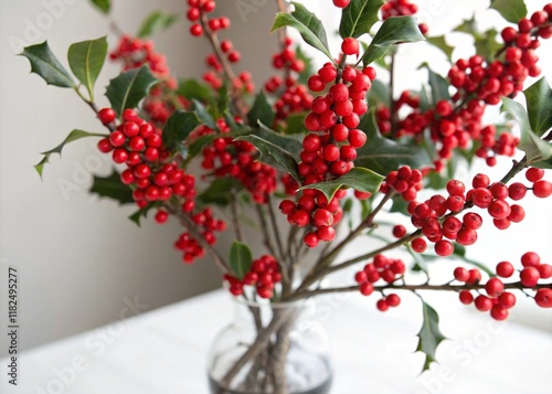 Vibrant Red-Berry Plant in a Clear Glass Vase on a White Surface photo