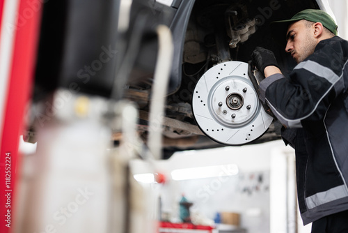 Quadro su tela Mechanic inspecting car brake disc in auto repair shop