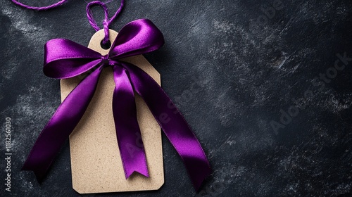 Gift tag with purple ribbon on dark textured background ready for celebration