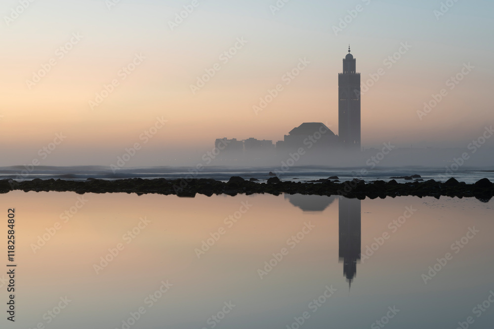 Fototapeta premium Africa, Morocco, Casablanca. Sunrise on mosque reflecting in ocean.