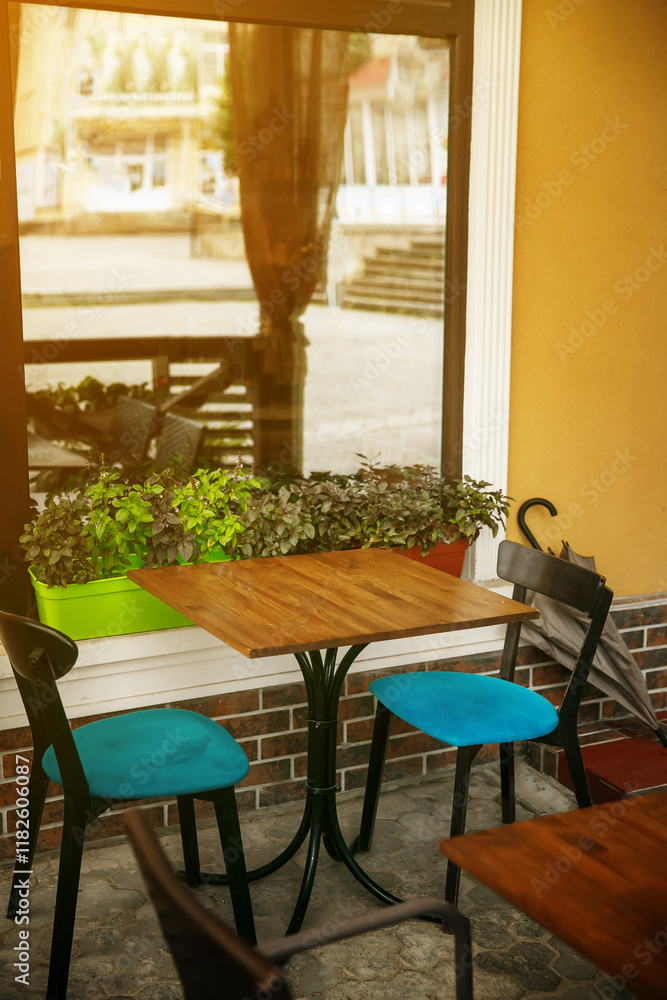 Fototapeta premium Coffeeshop front with table and a chairs selling garden plants