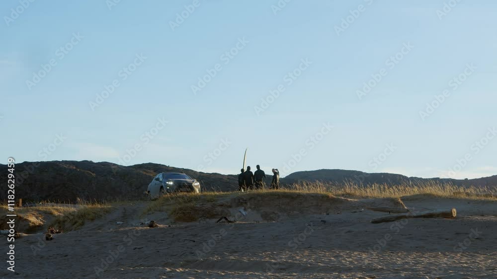 Group of surfers and divers, wearing wetsuits, are photographed on the beach in the middle of a cold tundra, before starting their surfing and diving classes. Group of surfers and divers, wearing wetsuits, are photographed on the beach in the middle of a cold tundra, before starting their surfing and diving classes.