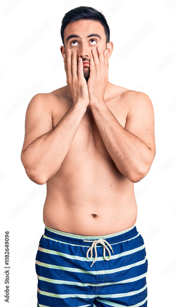 Fototapeta premium Young handsome man wearing swimwear tired hands covering face, depression and sadness, upset and irritated for problem