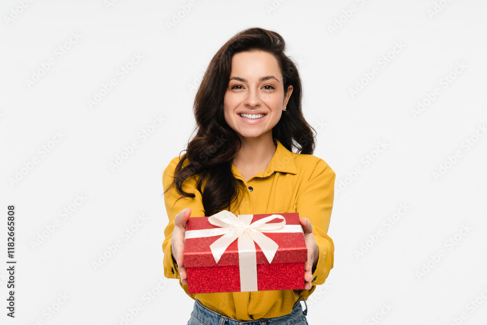 Portrait of a happy pretty latin hispanic woman holding giving red present box gift with white ribbon bow while standing and looking at camera isolated over white background Portrait of a happy pretty latin hispanic woman holding giving red present box gift with white ribbon bow while standing and looking at camera isolated over white background