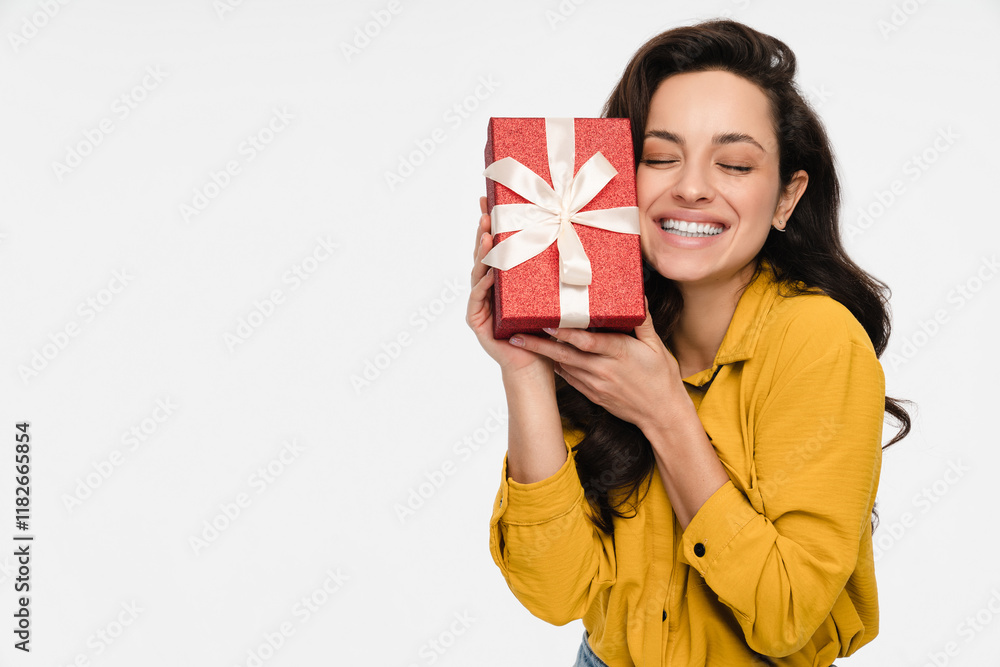 Image of a beautiful happy young brunette woman lady girl model holding present birthday gift box with closed eyes posing isolated over white wall background copy space for advertisement Image of a beautiful happy young brunette woman lady girl model holding present birthday gift box with closed eyes posing isolated over white wall background copy space for advertisement